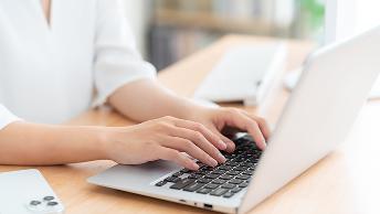 ノートパソコンでタイピングをしている様子