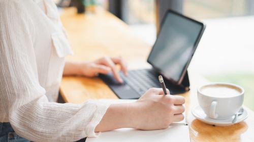 デスクでパソコンとノートで勉強をしているイメージ画像