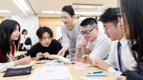 グループワークで学生たちと会話をする講師