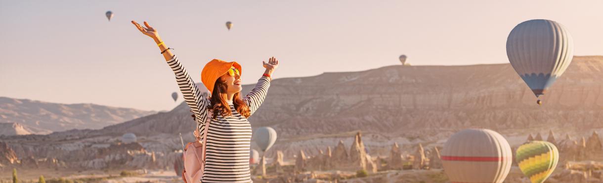 旅行先で手を広げている女性