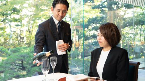 レストランスタッフがワインを注いでいる様子